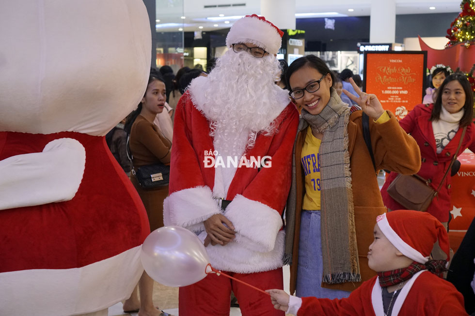A smiling lady in a photo with Santa Claus