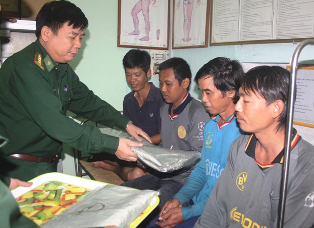 Đại tá Tôn Quốc Khánh, Chỉ huy trưởng BĐBP TP Đà Nẵng động viên, tặng áo ấm cho các nạn nhân bị mua bán, cưỡng ép lao động, sau khi được chăm sóc y tế.