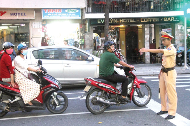  A local police officer to perform a check over a road user (Photo: Ngoc Phu)