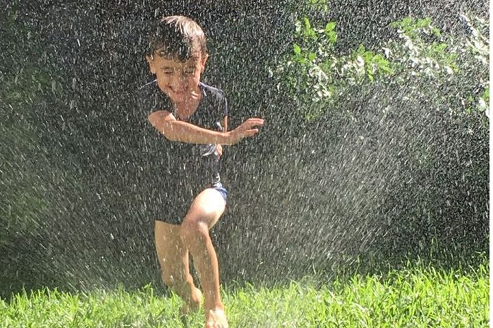 Trẻ em nô đùa với vòi nước để xoa dịu cái nóng mùa hè.
