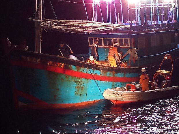 Rescuers transferring the victim from fishing boat BD 95395 TS to their rescue ship