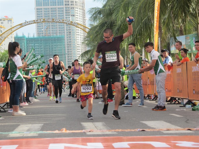In the family: A runner and his son cross the finish line in the Đà Nẵng marathon last year.— VNS Photo Công Thành Read more at http://vietnamnews.vn/sports/421141/da-nang-marathon-opens.html#TQFGW2sYgAAiOzkk.99