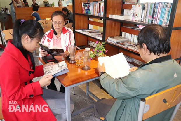 65-year-old Pham Hoan and his family members at the free public library (Photo: Ha Thu)