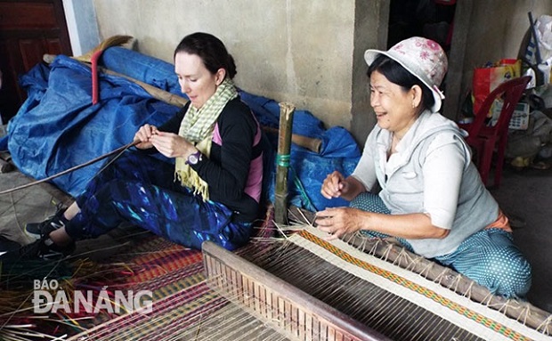 A foreign visitor (left) weaving sedge mats with a local resident in Hoa Vang District’s Cam Ne Village (Photo courtesy of the Management Board of ‘Cultures Connect’ project)