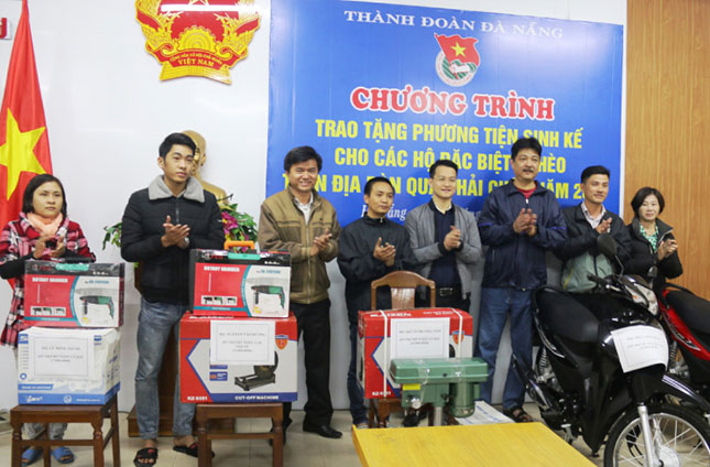Anh Nguyễn Mạnh Dũng, Phó Bí thư Thành Đoàn Đà Nẵng (thứ 4, phải qua) trao phương tiện sinh kế cho các hộ nghèo quận Hải Châu.