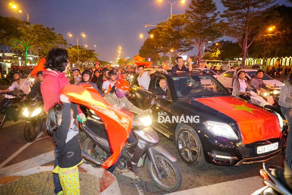 Fans with smiley faces waving the Vietnamese flag