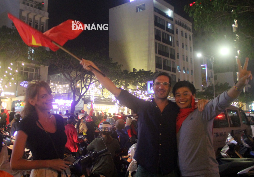 A foreigner also waving the Vietnamese flag whilst immersing himself into the bustling and jubilant atmosphere