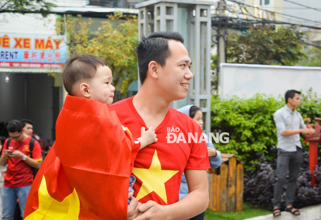  A man, along with his son, sporting red T-shirts, the colour of Viet Nam's national flag, in support for the Vietnamese squad