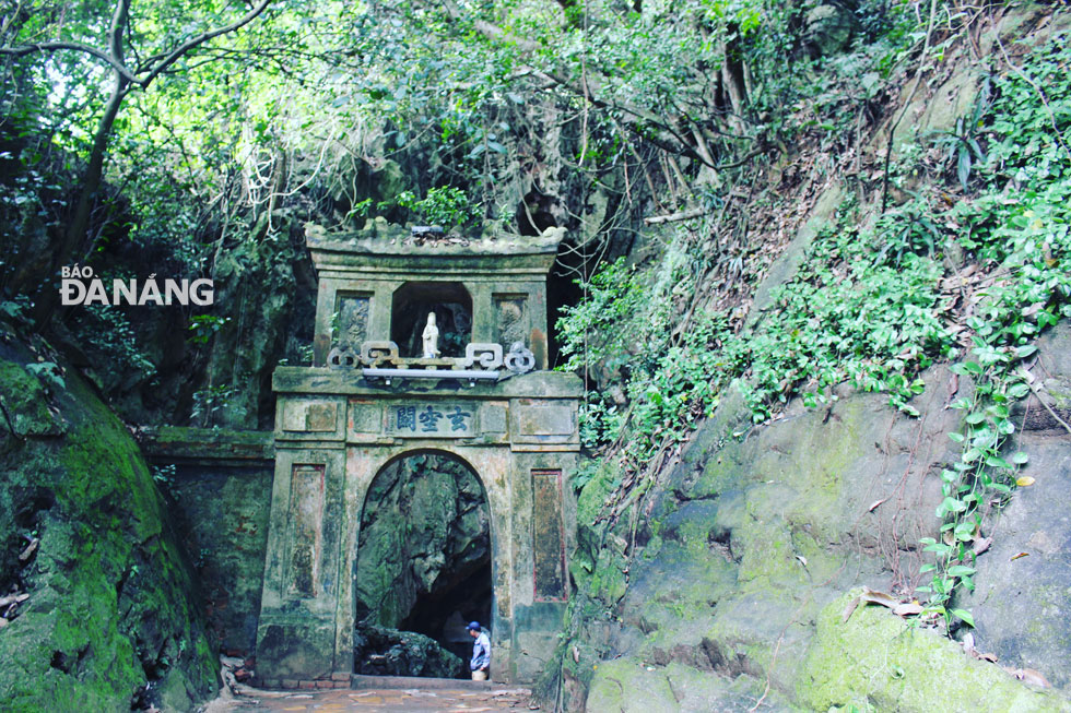 Cổng vào động Quan Âm nằm gần ngay sau chùa Tam Thai bị che phủ bởi cây cối