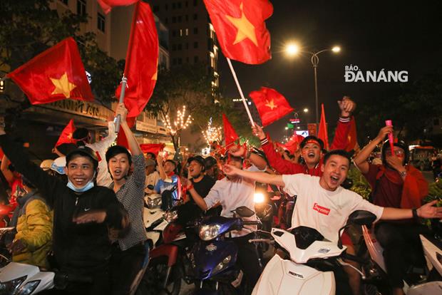 Fans with smiley faces waving the Vietnamese flag