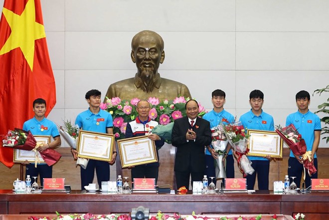 Prime Minister Nguyen Xuan Phuc presenta the Labour Order, first class, to the national U23 squad, the third-class Labour Order to head coach Park Hang-seo from the Republic of Korea, midfielder Nguyen Quang Hai and goalkeeper Bui Tien Dung. (Photo: VNA)