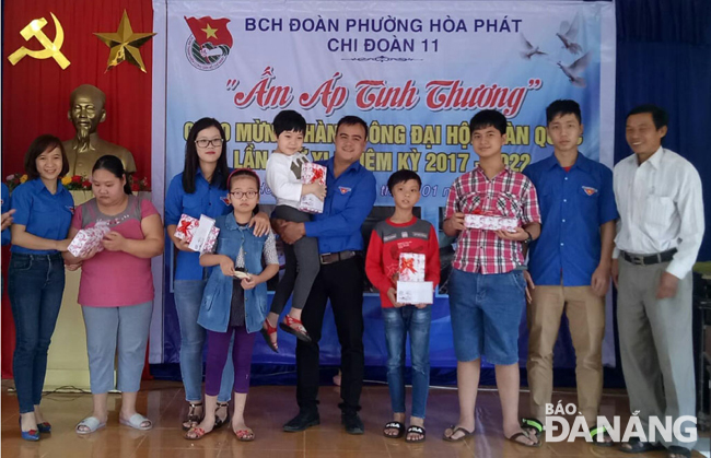 Anh Đinh Xuân Đức (giữa) cùng các đoàn viên trao quà cho trẻ em.