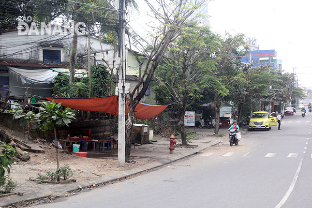 Vỉa hè phía lô đất trống cạnh nhà số 22 Nguyễn Thế Lộc được người dân che bạt tạm, bày nhiều loại vật dụng, bàn ghế buôn bán.
