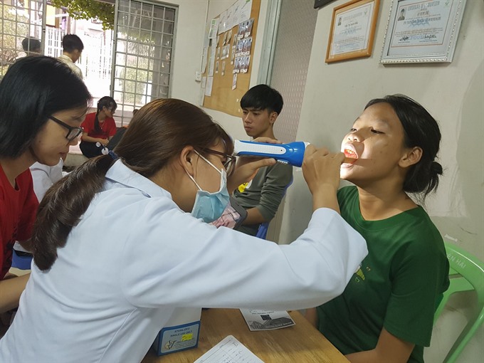 Say aaaah: Doctors participating in the Vietnam Social Health Revolution examine children under one of the projects of the organisation. — Photo from Facebook of Vietnam Social Health Revolution Read more at http://vietnamnews.vn/life-style/expat-corner/422219/volunteer-doctors-work-to-provide-universal-healthcare.html#y9eFRFSwkq2rxRUf.99