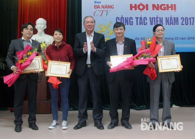 Tổng Biên tập Báo Đà Nẵng Trương Công Định (giữa) trao giấy khen cho các cộng tác viên xuất sắc năm 2017.                 Ảnh: TRỌNG HUY
