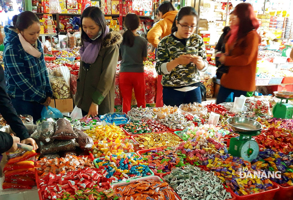 Tại các chợ, bánh kẹo, các loại mứt đã lên đầy trên sạp, bày la liệt với đủ loại màu sắc thu hút người nội trợ. Ảnh: THU THẢO
