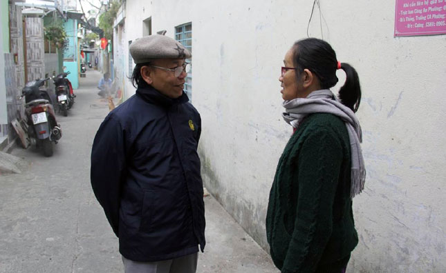 Phó Bí thư chi bộ KDC 8 Phan Quang Bình (bên trái) trao đổi với người dân về chủ trương hiến đất mở rộng kiệt 210, đường Trần Cao Vân.