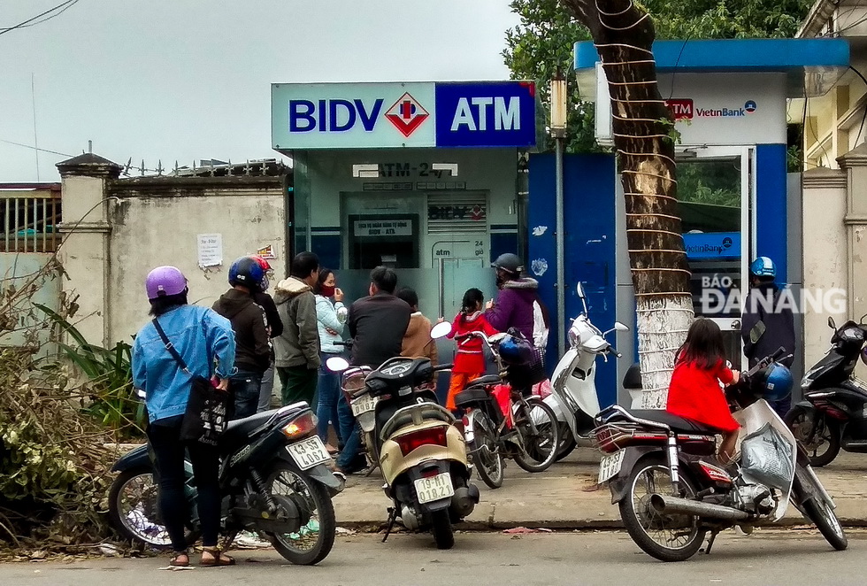 Người dân xếp hàng chờ giao dịch trước cụm điểm ATM trên đường Ông Ích Đường (quận Cẩm Lệ)
