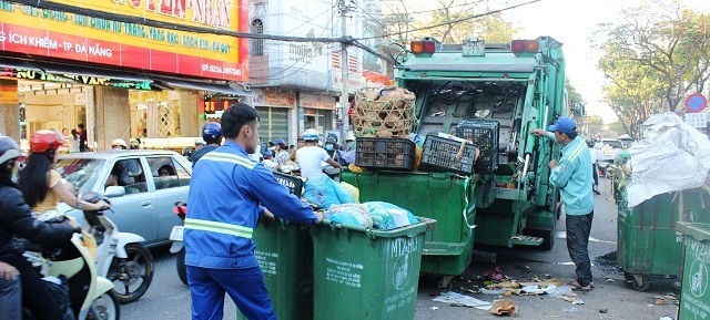 Các công nhân Công ty CP Môi trường đô thị Đà Nẵng tất bật thu gom rác thải tại khu vực trước chợ Cồn.