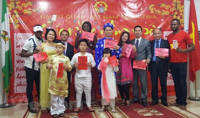 Vietnamese Ambassador to Nigeria Pham Anh Tuan (blue long-dress) and overseas Vietnamese join Nigerian friends at get-together to welcome Tet (Source: VNA)