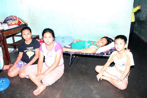 Mrs Lai (lying on the folding bed) and her 3 children