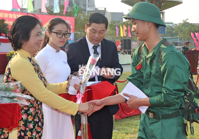 Chủ tịch Ủy ban MTTQ Việt Nam thành phố Đặng Thị Kim Liên và lãnh đạo quận Thanh Khê tặng hoa chúc mừng cho các tân binh tại điểm giao quân Thanh Khê. Ảnh: NGỌC HÀ