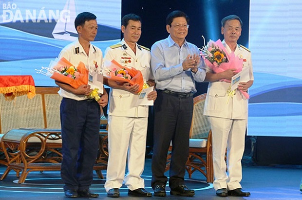 Da Nang Party Committee Deputy Secretary Vo Cong Tri (2nd, right) presenting flowers to invited guests