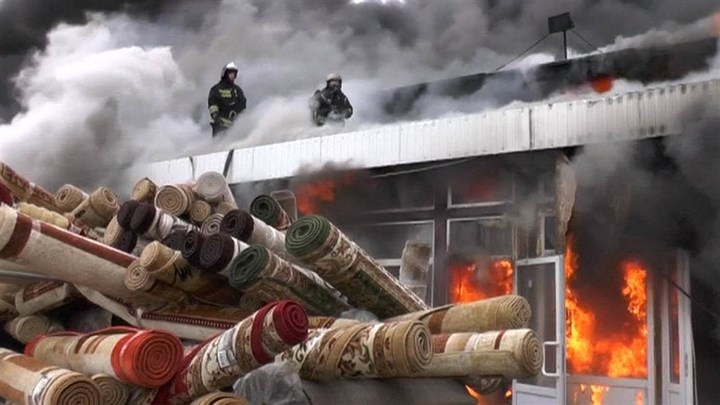   Bất chấp nguy hiểm, các nhân viên cứu hỏa trèo lên mái trung tâm thương mại để dập lửa. Ảnh: WPSD.