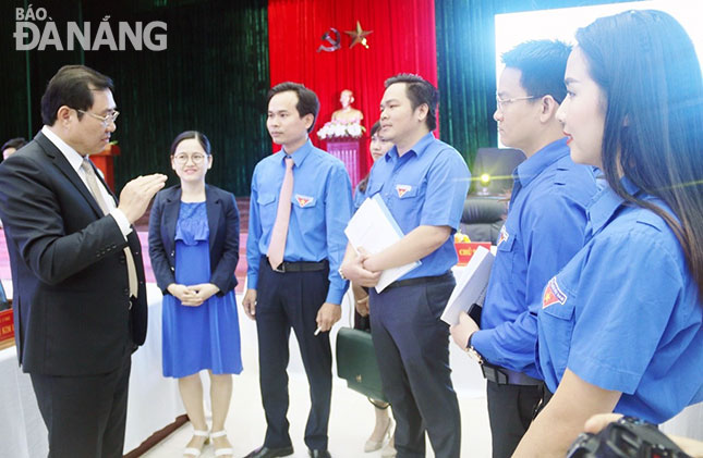 Chủ tịch UBND thành phố Huỳnh Đức Thơ (trái) trao đổi với thanh niên về việc xây dựng thành phố thông minh. 