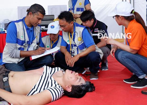 In a nearby area, an EMT from Myanmar giving first aid and emergency treatment for a local resident suffered from suffocation and respiratory failure