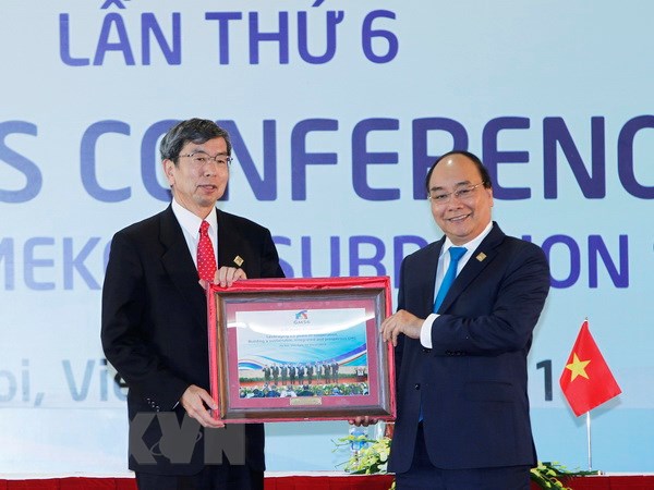 Thủ tướng Nguyễn Xuân Phúc tặng Chủ tịch Ngân hàng Phát triển châu Á (ADB) Takehiko Nakao bức ảnh do phóng viên TTXVN chụp các Trưởng đoàn tham dự Hội nghị Thượng đỉnh GMS 6. (Ảnh: TTXVN)