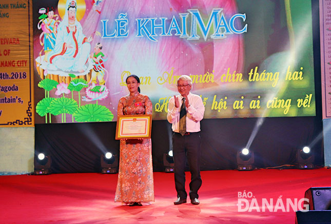 Photo: A representative from the Ministry of Culture, Sports and Tourism presents a Certificate of Merit to the festival’s organisers. (Photo: Ngoc Ha)