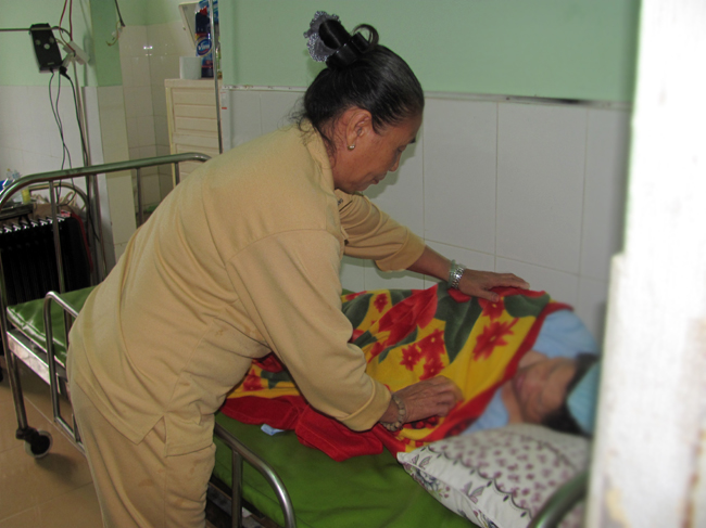Bà Vũ Thị Lành chăm sóc cụ già nằm bất động tại Trung tâm Bảo trợ xã hội Đà Nẵng.
