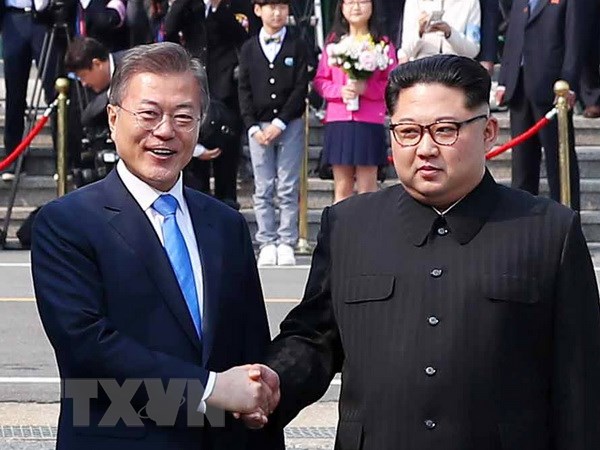 Tổng thống Hàn Quốc Moon Jae-in (trái) bắt tay hữu nghị Nhà lãnh đạo Triều Tiên Kim Jong-un (phải) tại làng đình chiến Panmunjom. (Nguồn: YONHAP/TTXVN)