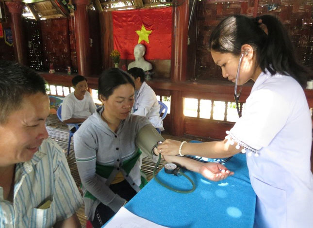 Các y sĩ  Trạm y tế xã Hòa Phú khám bệnh cho dân tại nhà Gươl thôn Phú Túc (xã Hòa Phú). Ảnh: T.T