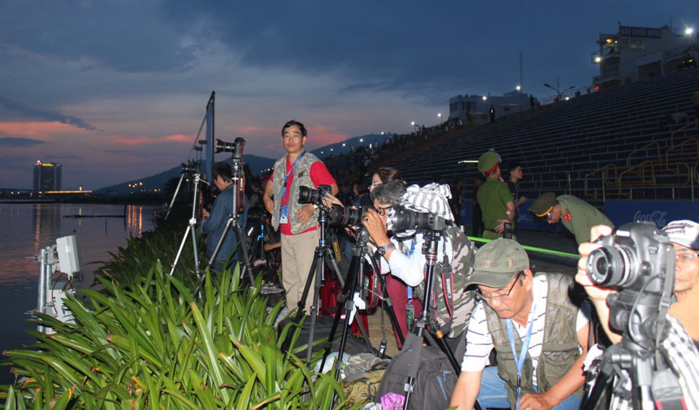 Các phóng viên ảnh đã có mặt tại khu vực sát bờ sông để chuẩn bị máy móc, dụng cụ cho những tấm ảnh pháo hoa đẹp nhất. Ảnh: KHANG NINH