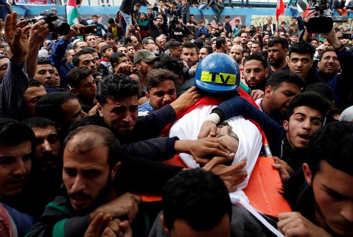 Thi thể nhà báo Palestine Ahmed Abu Hussein được những người đưa tang rước đi ở Dải Gaza vào ngày 26/4.
