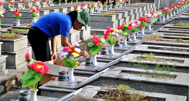 A Youth Union member burning incense at a martyr's grave in Da Nang 