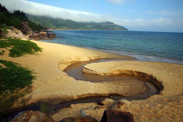   An impressive water flow after heavy rain pouring down the Bai Cat Vang (Yellow Sand Beach) of the Bai But Beach on the Son Tra Peninsula (Photo: Nhan Mui)