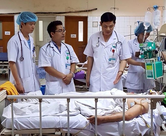 Bác sỹ Lương (ngoài cùng bên trái) cùng các bác sỹ khác theo dõi tình hình sức khỏe cho một bệnh nhân. (Ảnh: PV/Vietnam+)