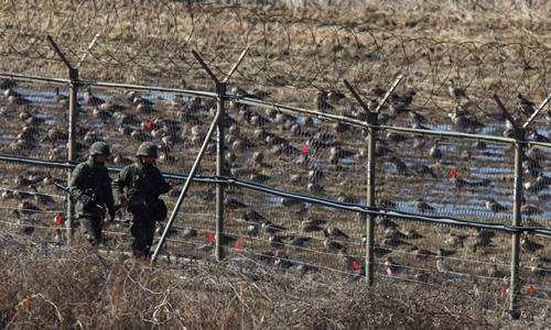 Lính Hàn Quốc tuần tra hàng rào dây thép gai gần Khu Phi quân sự tháng 3/2013. Ảnh: AFP.
