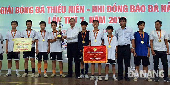 DA NANG Newspaper’s Editor-in-Chief Truong Cong Dinh (5th, left), and Deputy Director of the Department of Culture and Sports Nguyen Trong Thao (3rd, right), with junior school champions Tran Dai Nghia