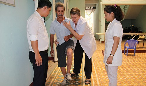 Ms Lockett helping a patient exercise at the Traditional Medicine Hospital 