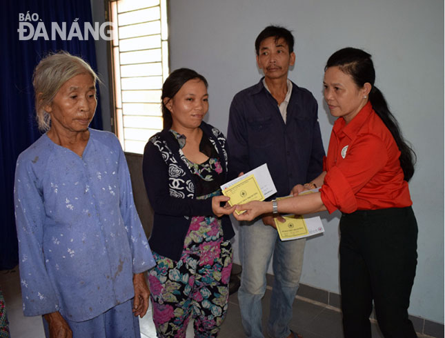 Mrs Chi (right) presenting gifts to needy people