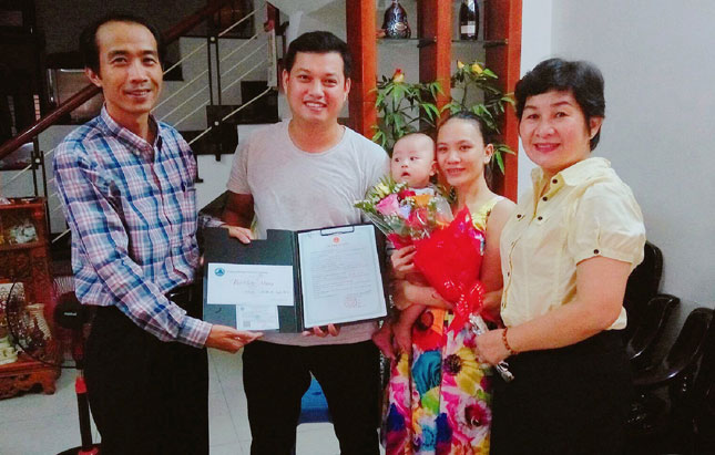Lãnh đạo UBND phường Hải Châu 1 trao giấy khai sinh, thư chúc mừng công dân mới và thẻ bảo hiểm y tế tại nhà công dân.