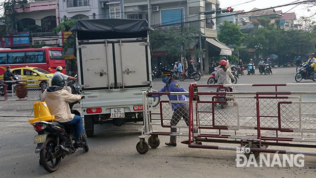 Ô-tô, xe máy vẫn cố tình băng qua đường sắt khi nhân viên đường sắt tiến hành đóng gác chắn. Ảnh: Hoàng Nhung