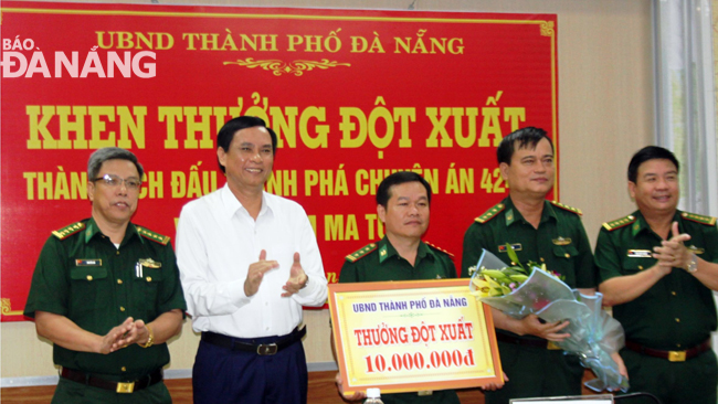 Municipal People’s Committee Vice Chairman Tran Van Mien (2nd, left) presenting a reward in cash to representatives from the Criminals and Drug-related Crime Investigation Division