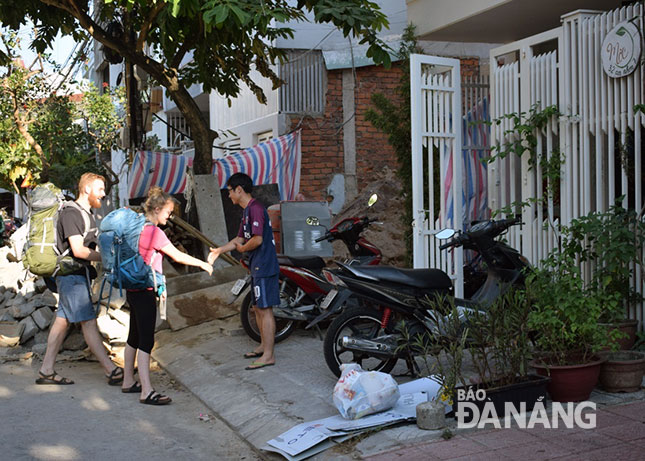 Chủ một cơ sở homestay trên đường An Nhơn 7 đón khách nước ngoài đến lưu trú tại nhà mình.