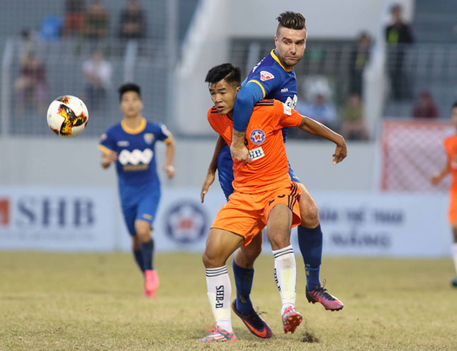 SHB’s striker Ha Duc Chinh (in orange) was closely marked by a foreign rival