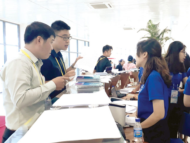Phóng viên Báo Đà Nẵng (trái) và tình nguyện viên hướng dẫn, cung cấp thông tin đến phóng viên tác nghiệp ở Trung tâm Báo chí quốc tế trong Tuần lễ Cấp cao APEC 2017 tại Đà Nẵng. Ảnh: Cẩm Kim